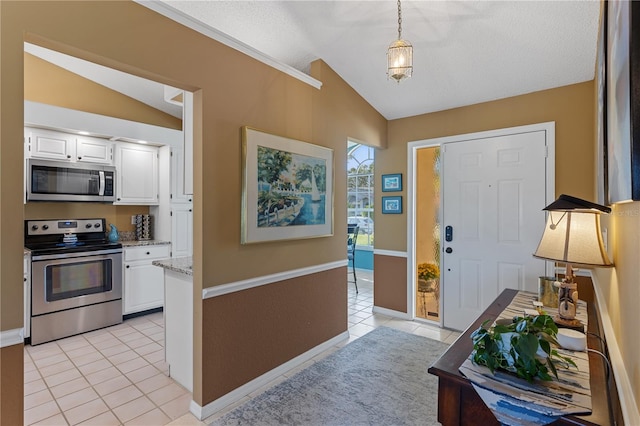 tiled foyer entrance with vaulted ceiling and a textured ceiling