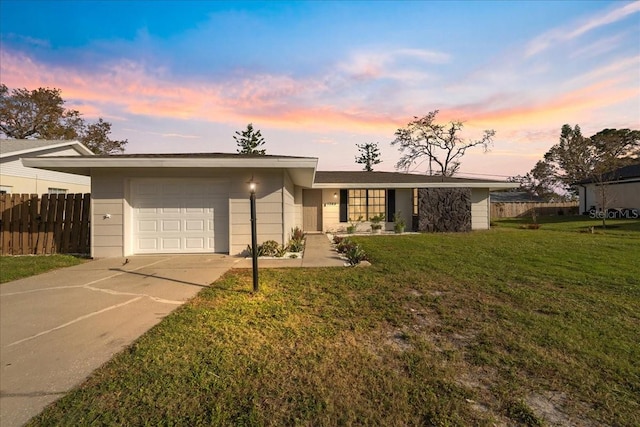 single story home featuring a lawn and a garage