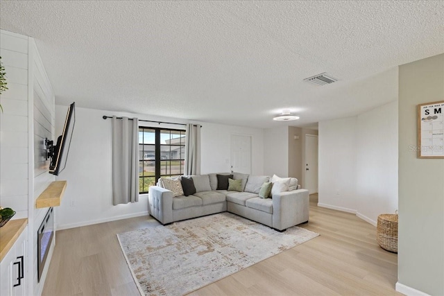 living room featuring a textured ceiling and light hardwood / wood-style flooring