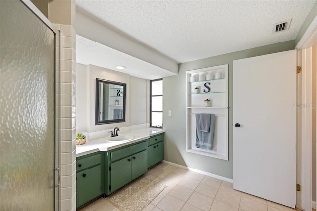 bathroom with vanity, a textured ceiling, tile patterned floors, and a shower with door