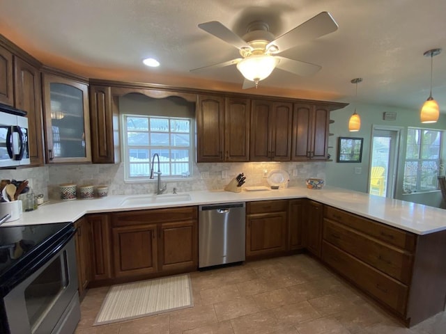 kitchen with black range with electric stovetop, dishwasher, sink, kitchen peninsula, and pendant lighting