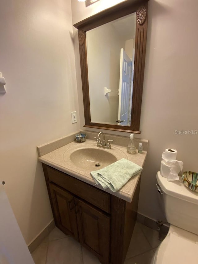 bathroom featuring tile patterned flooring, vanity, and toilet