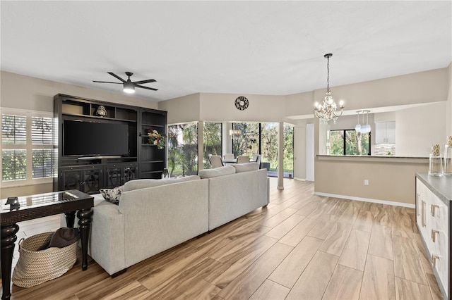 living room with light hardwood / wood-style flooring and ceiling fan with notable chandelier