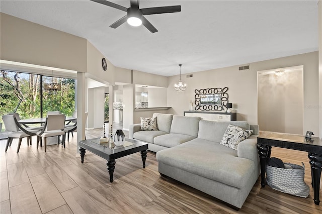 living room featuring hardwood / wood-style flooring and ceiling fan with notable chandelier