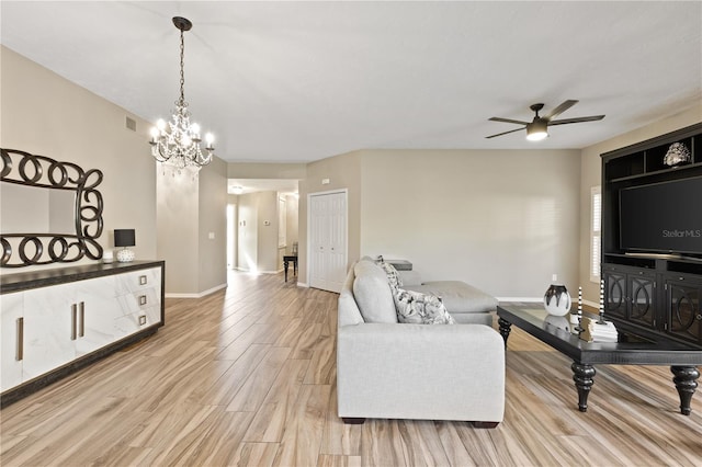 living room featuring light hardwood / wood-style flooring and ceiling fan with notable chandelier