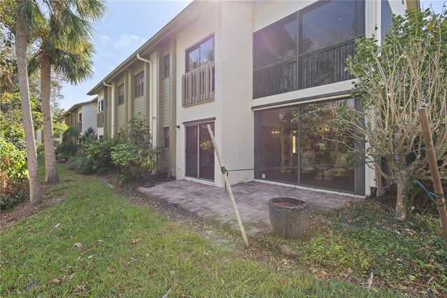 rear view of house with a patio area and a lawn