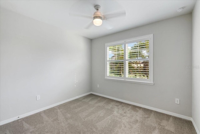 spare room featuring ceiling fan and light colored carpet