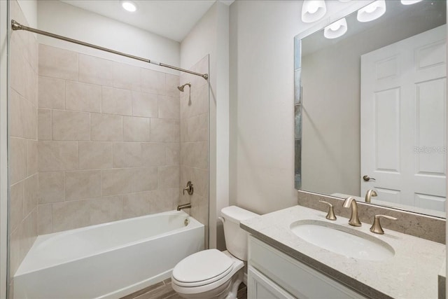 full bathroom with toilet, tiled shower / bath combo, and vanity