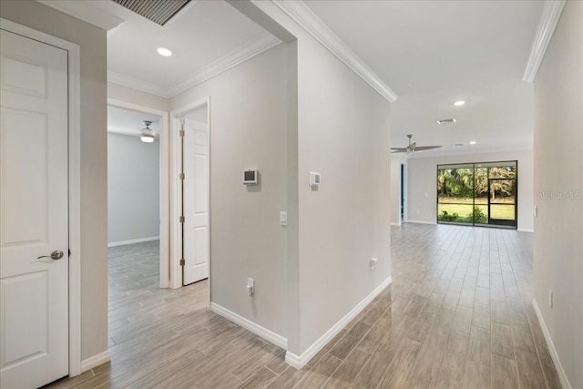 hallway with light hardwood / wood-style floors and crown molding