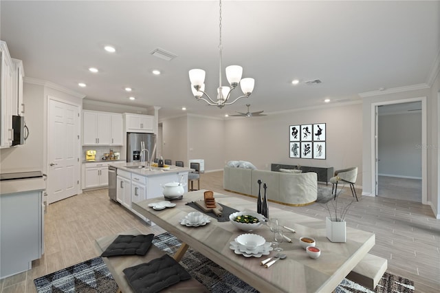 dining space featuring ornamental molding, ceiling fan with notable chandelier, and light wood-type flooring