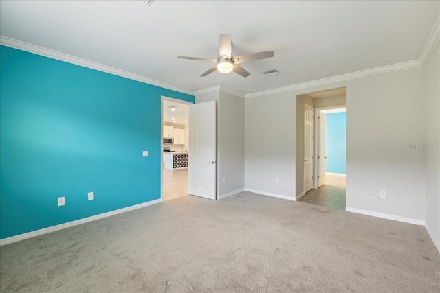 empty room with ornamental molding, light colored carpet, and ceiling fan