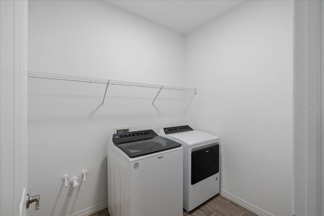 washroom with wood-type flooring and washing machine and clothes dryer