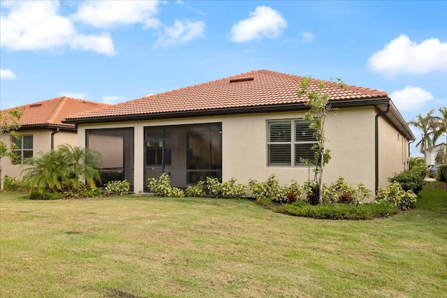 rear view of house featuring a lawn