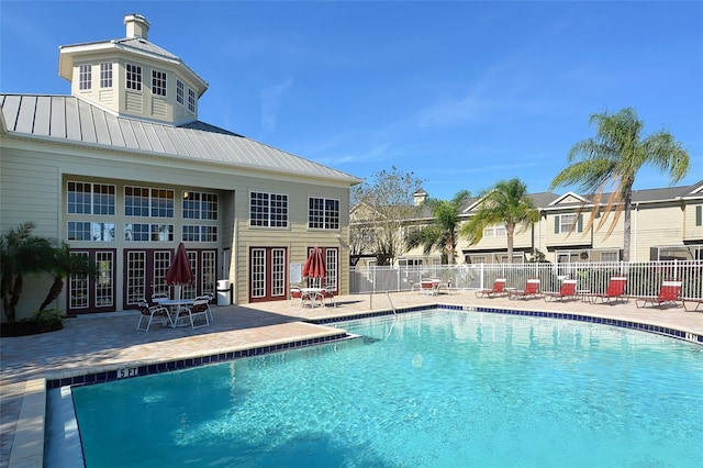 view of swimming pool with french doors and a patio area