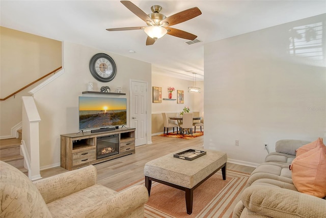 living room with light wood-type flooring and ceiling fan