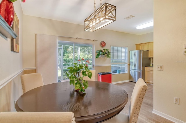 dining room featuring an inviting chandelier and light hardwood / wood-style flooring