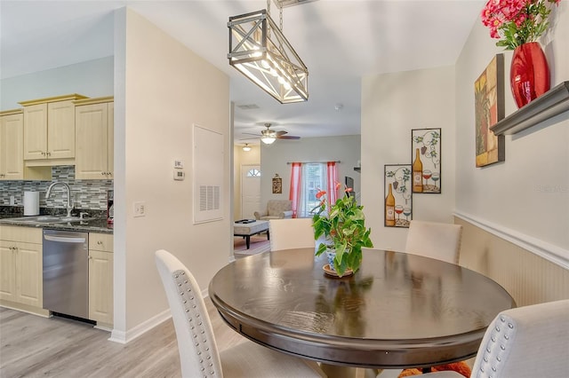 dining area featuring ceiling fan, sink, and light wood-type flooring