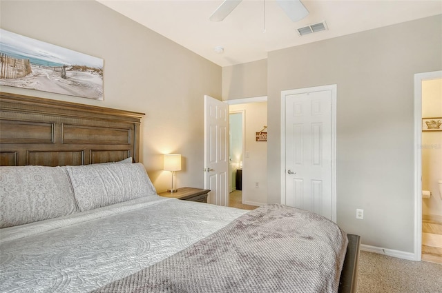 bedroom with ensuite bathroom, ceiling fan, and light carpet