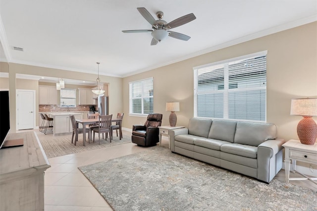 living room featuring ceiling fan, light tile patterned floors, and crown molding