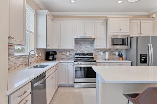 kitchen with sink, light tile patterned floors, ornamental molding, a kitchen bar, and stainless steel appliances