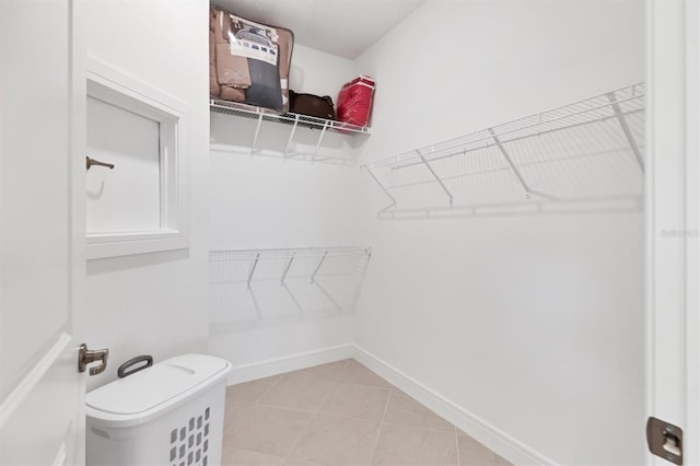 walk in closet with light tile patterned floors