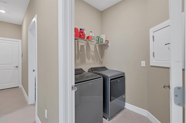 washroom with washer and clothes dryer and light tile patterned floors