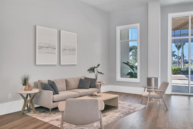 living room featuring a wealth of natural light and dark wood-type flooring