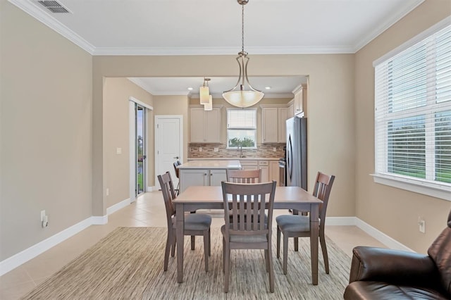 tiled dining room featuring crown molding and sink