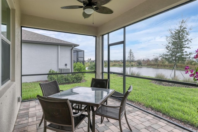 sunroom / solarium featuring a water view and ceiling fan