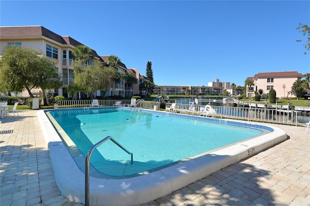 view of swimming pool with a water view and a patio