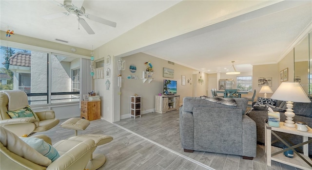 living room with ceiling fan and crown molding