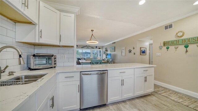 4380 Exeter Dr Unit 303, Longboat Key, FL 34228 - kitchen featuring dishwasher, a sink, a peninsula, crown molding, and white cabinetry