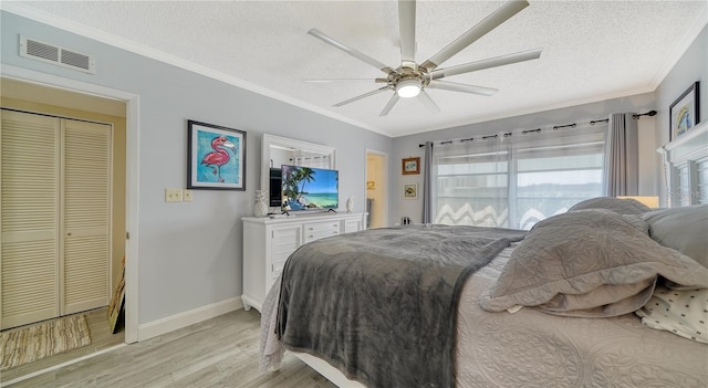 bedroom with light wood-type flooring, ceiling fan, a textured ceiling, and a closet