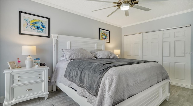 bedroom featuring light wood-type flooring, a closet, ceiling fan, and ornamental molding