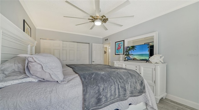 bedroom with a closet, ceiling fan, ornamental molding, and light hardwood / wood-style floors