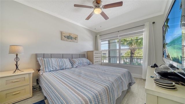 bedroom featuring ceiling fan, ornamental molding, light hardwood / wood-style floors, and a textured ceiling