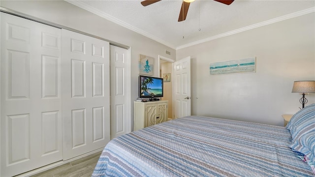 bedroom with light hardwood / wood-style floors, a textured ceiling, a closet, and ceiling fan