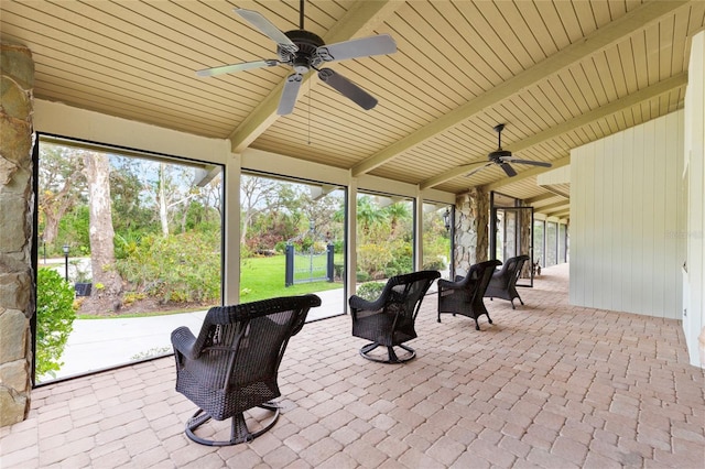 sunroom / solarium featuring beam ceiling, ceiling fan, and wood ceiling