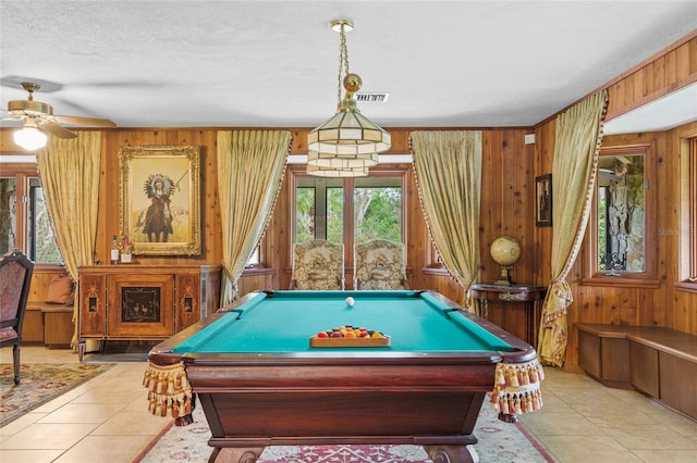 rec room with wooden walls, billiards, ceiling fan, light tile patterned floors, and a textured ceiling