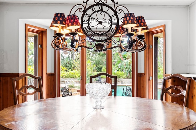 dining area featuring wood walls and an inviting chandelier