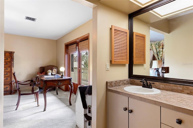 bathroom with tasteful backsplash and vanity