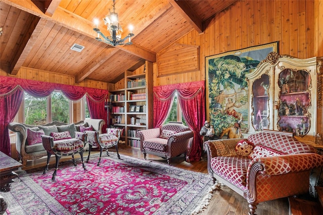 living area with wood walls, a healthy amount of sunlight, hardwood / wood-style flooring, and an inviting chandelier