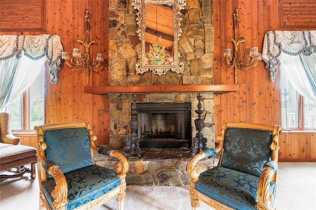 sitting room featuring a fireplace, carpet floors, and wood walls