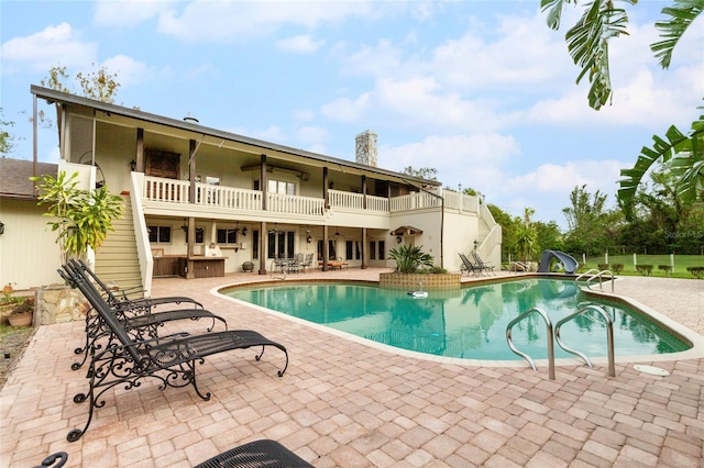 view of swimming pool with a patio area and a water slide