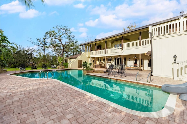 view of pool with a patio area and a water slide