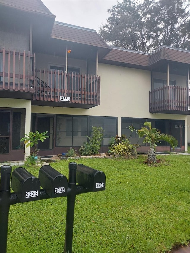 exterior space featuring a balcony and a lawn