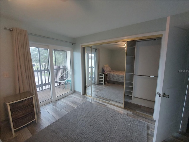 unfurnished bedroom with a closet, access to outside, and hardwood / wood-style flooring