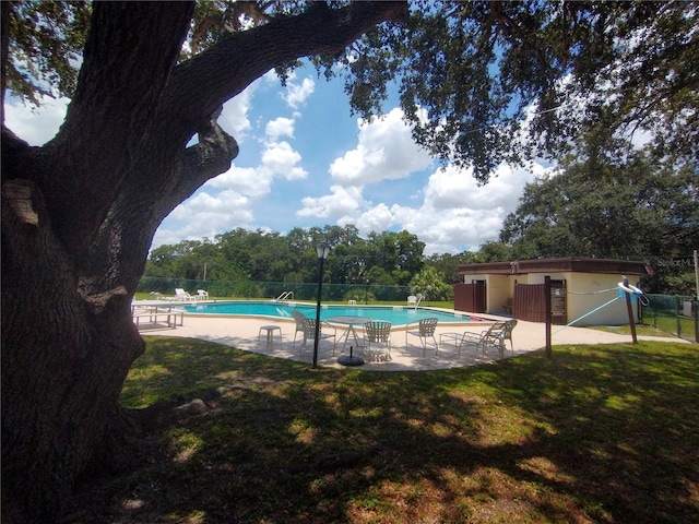 view of swimming pool featuring a lawn and a patio