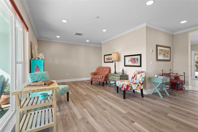 living area with ornamental molding and light wood-type flooring