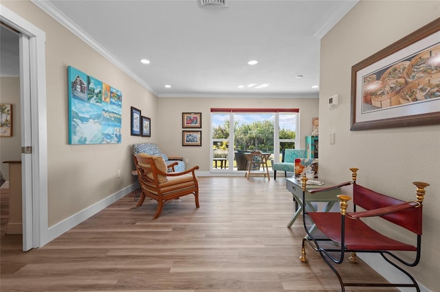 sitting room featuring light wood-type flooring and ornamental molding